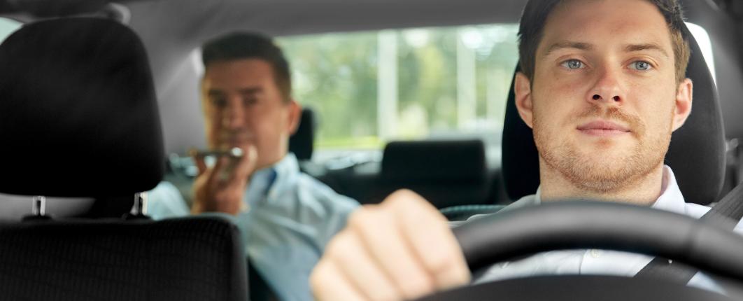 image d'un chauffeur de taxi avec un client sur les places arrières de la voiture