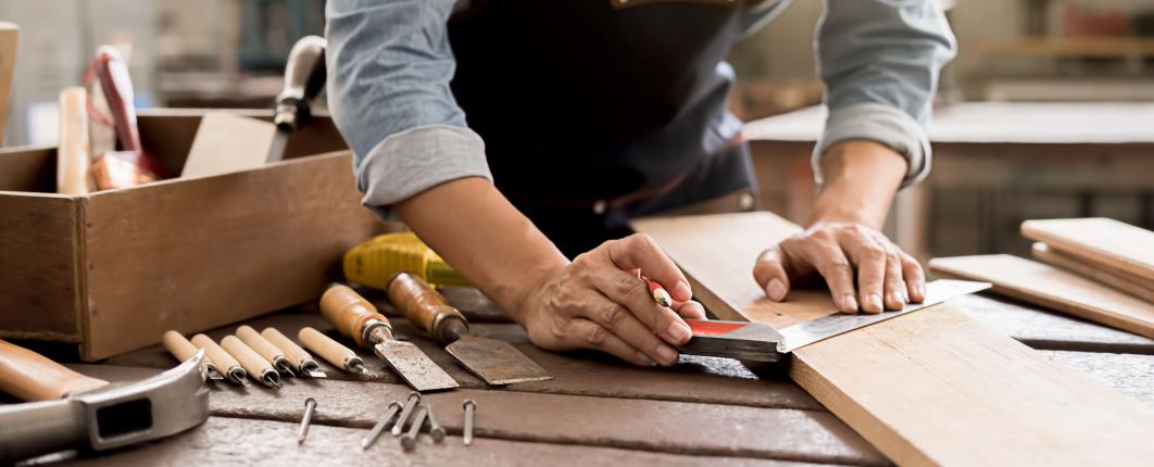 des mains qui font un travail sur bois