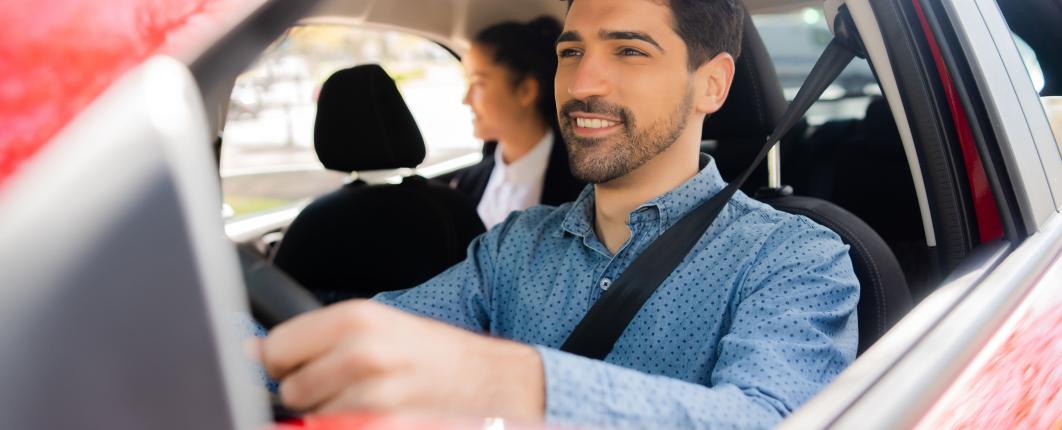 chauffeur de taxi au volant avec une cliente à l'arrière 