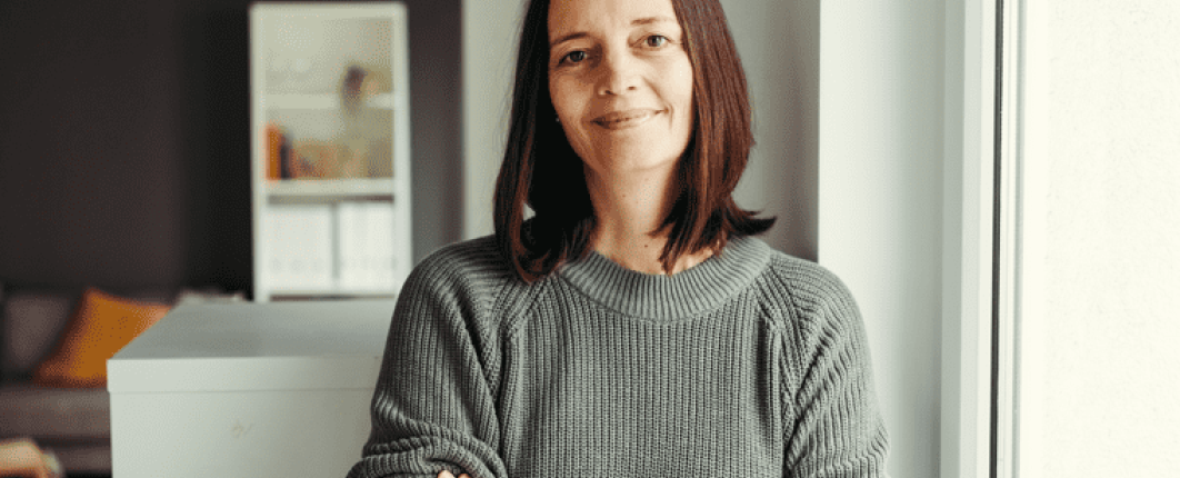 une femme souriante croisant les bras 