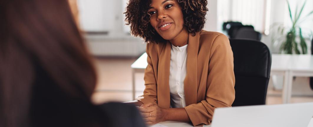 Jeune femme assise à un bureau qui discute