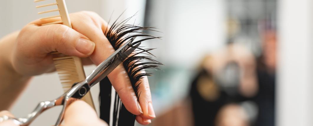 Focus sur une personne en train de couper une mèche de cheveux dans un salon de coiffure