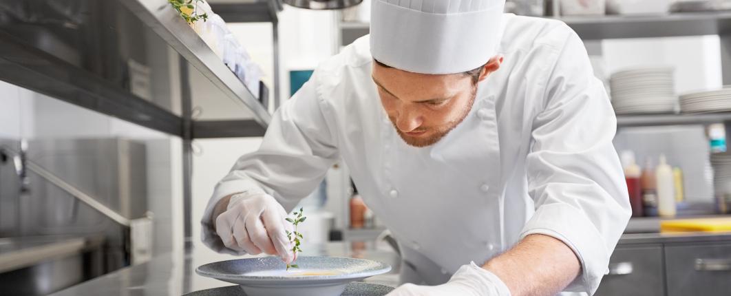 une personne de cuisine sert une soupe