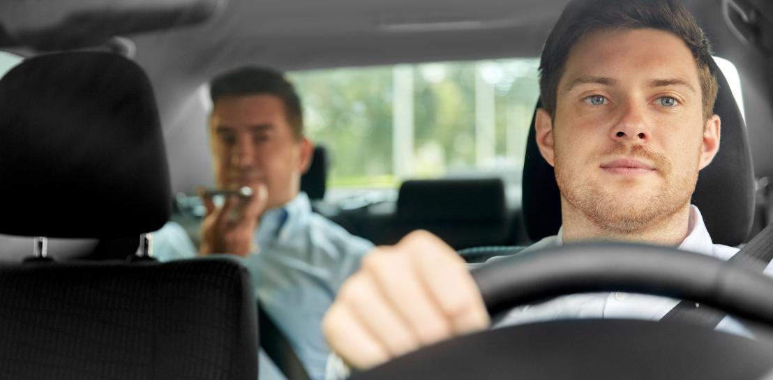 image d'un chauffeur de taxi avec un client sur les places arrières de la voiture