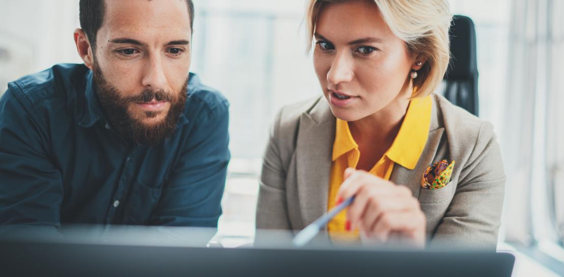 femme qui montre quelque chose sur son écran à un homme
