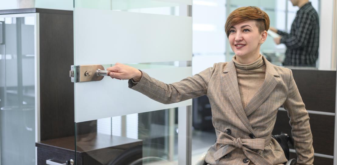 personne en fauteuil qui ouvre une porte 