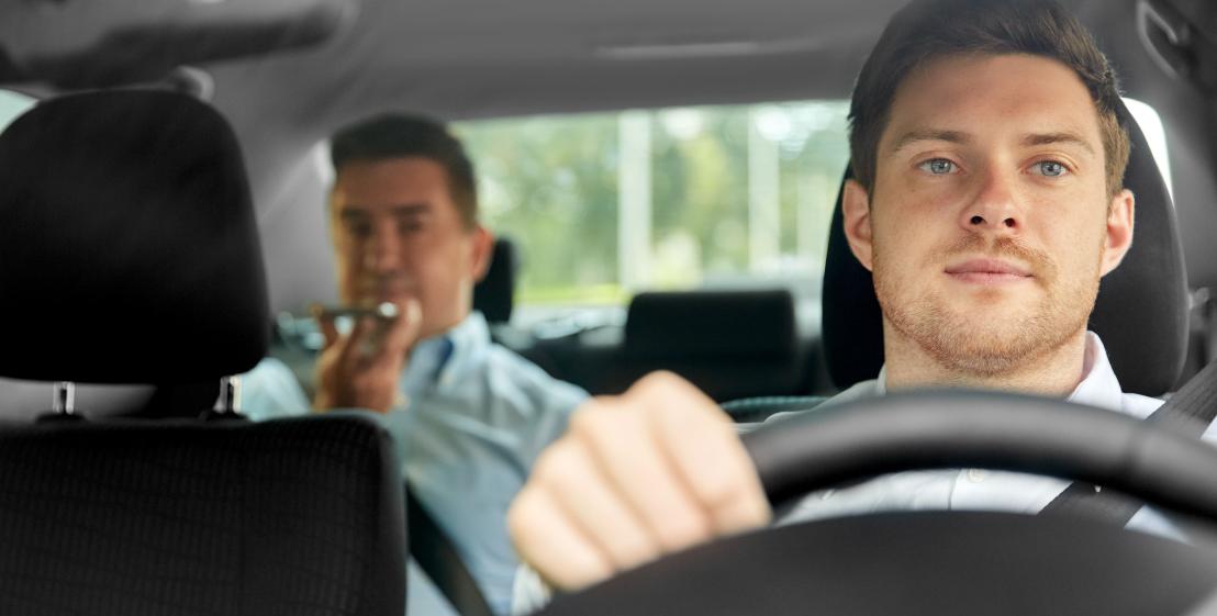 image d'un chauffeur de taxi avec un client sur les places arrières de la voiture