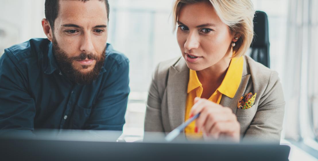 femme qui montre quelque chose sur son écran à un homme