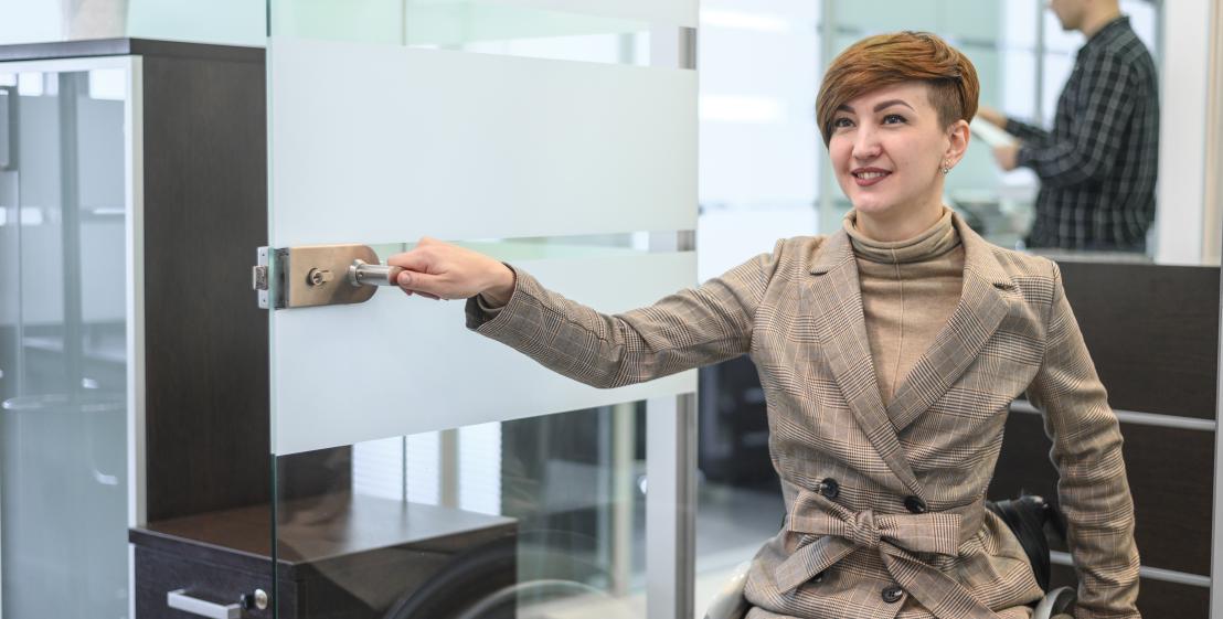 personne en fauteuil qui ouvre une porte 