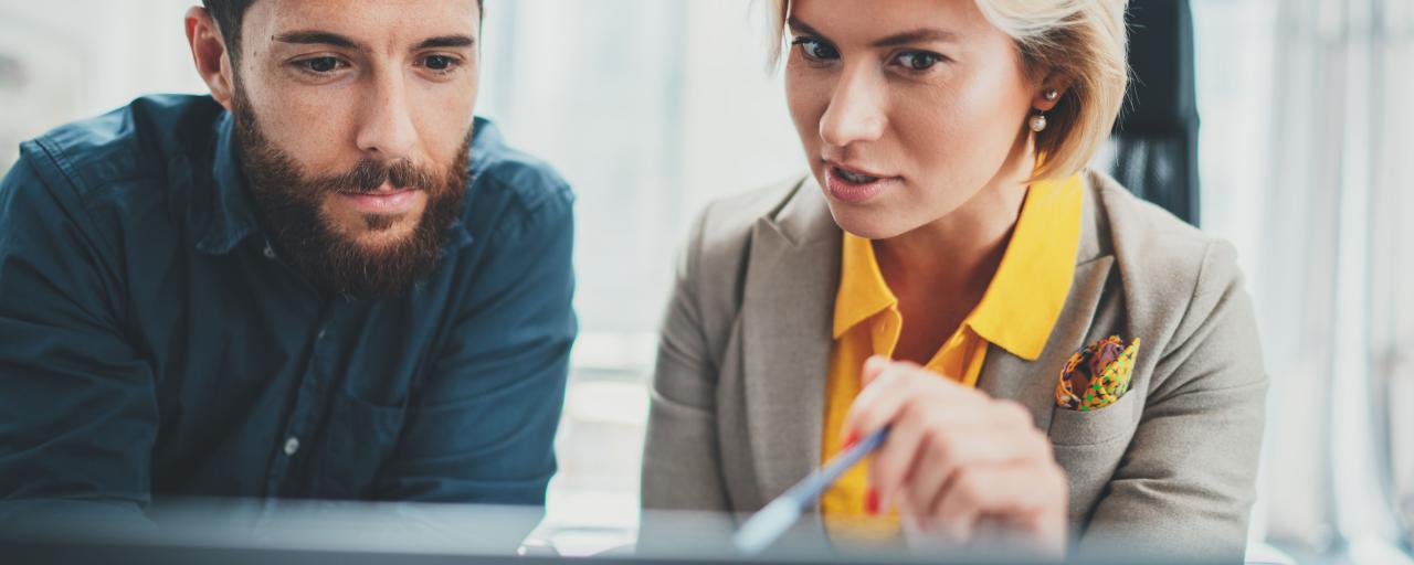 femme qui montre quelque chose sur son écran à un homme