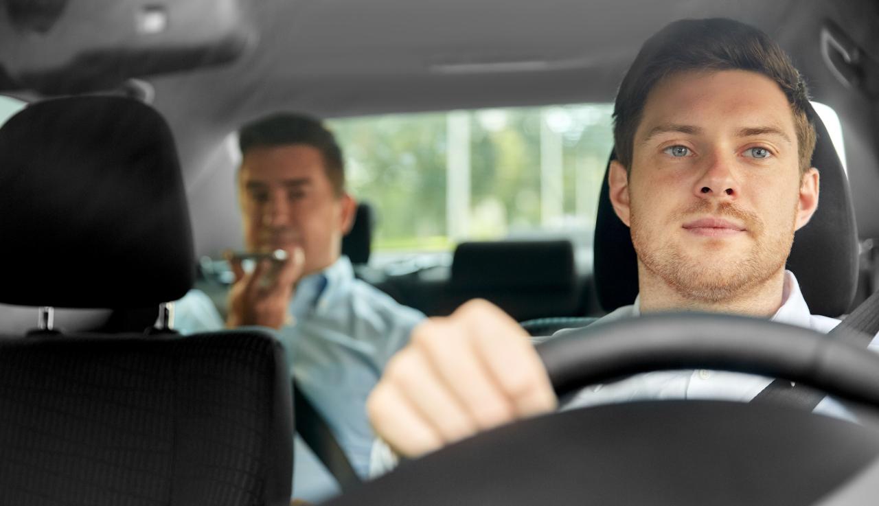 image d'un chauffeur de taxi avec un client sur les places arrières de la voiture