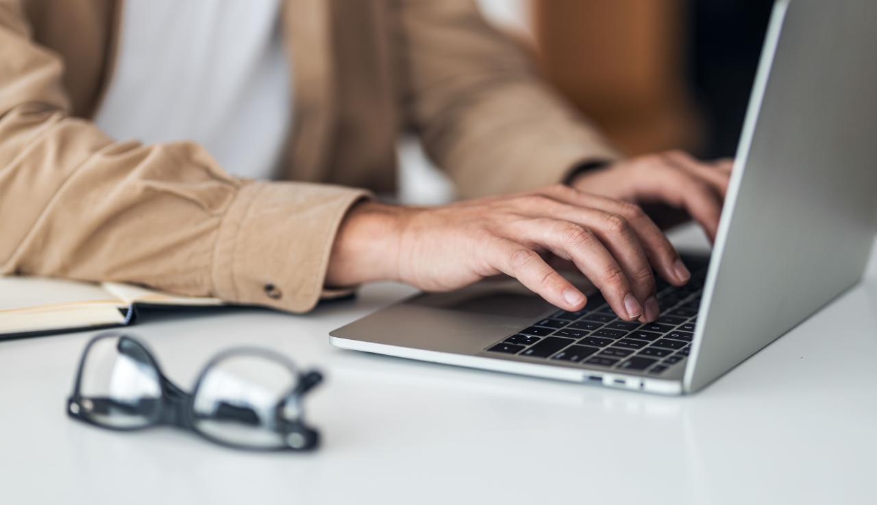 Personne tapant sur le clavier d'un ordinateur portable 