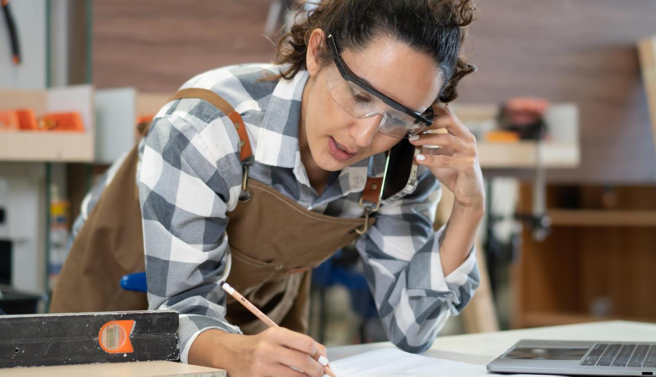 Femme menuisière qui écrit quelque chose sur une feuille