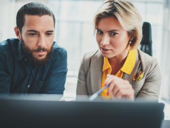 femme qui montre quelque chose sur son écran à un homme