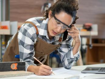 Femme menuisière qui écrit quelque chose sur une feuille