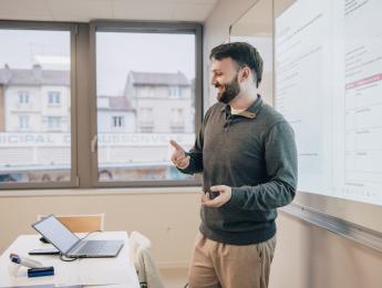 un professeur est devant un tableau et donne un cours