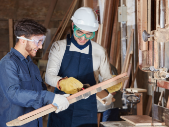 Un apprenti et son maitre d'apprentissage travaillent dans un atelier
