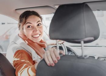 image d'une femme chauffeur de taxi qui se retourne au volant