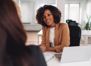 Jeune femme assise à un bureau qui discute