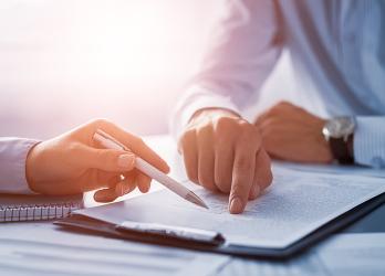 Photo d'une signature d'un contrat d'apprentissage avec un focus sur le contrat et les mains des interlocuteurs