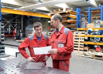 un apprenti avec son tuteur dans un atelier