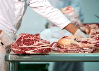un boucher qui coupe des morceaux de viande