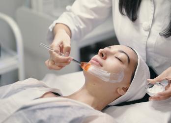 Femme en train d'appliquer un masque à une cliente 