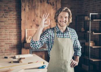 Homme souriant qui fait un signe 'ok' avec ses doigts 