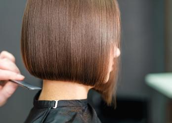 Femme brune avec un carré en train de se faire coupé les cheveux 
