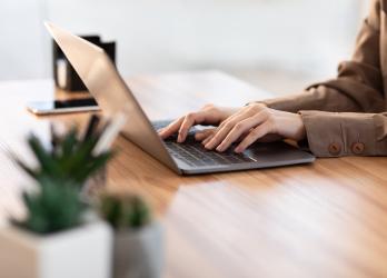 Une personne en train de taper sur le clavier de son PC portable 