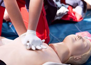 Personne faisant un massage cardiaque à un mannequin 