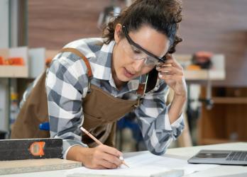 Femme menuisière qui écrit quelque chose sur une feuille