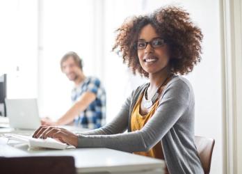 Photo d'une jeune femme travaillant son dossier de VAE sur ordinateur