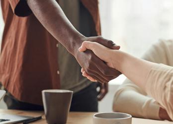 Photo d'une poignée de main entre un jeune apprenti et son employeur