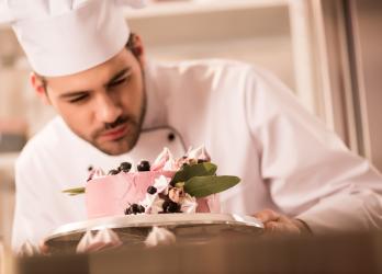 Un pâtissier fait un gâteau rose