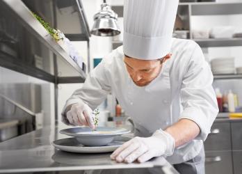 une personne de cuisine sert une soupe