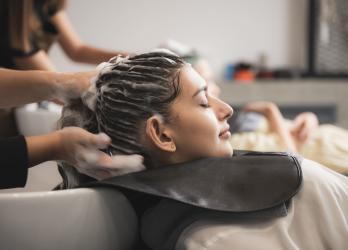 une coiffeuse fait un shampoing à une cliente 