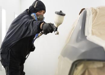 employe-de-service-peignant-une-voiture-en-service-automobile