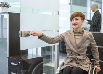 personne en fauteuil qui ouvre une porte 