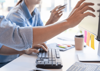 Photo de deux personnes devant un écran d'ordinateur pour une formation CMA Formation