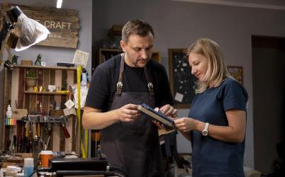 un homme et une femme regardent un carnet dans un atelier 