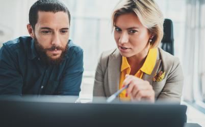 femme qui montre quelque chose sur son écran à un homme