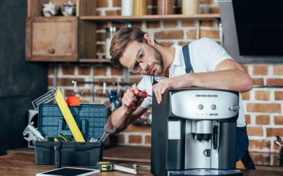Un homme réparant une machine à café