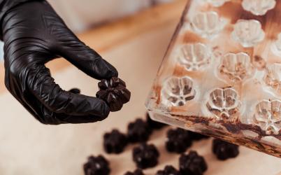 Main avec un gant qui retire un chocolat d'un moule