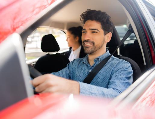 chauffeur de taxi au volant avec une cliente à l'arrière 