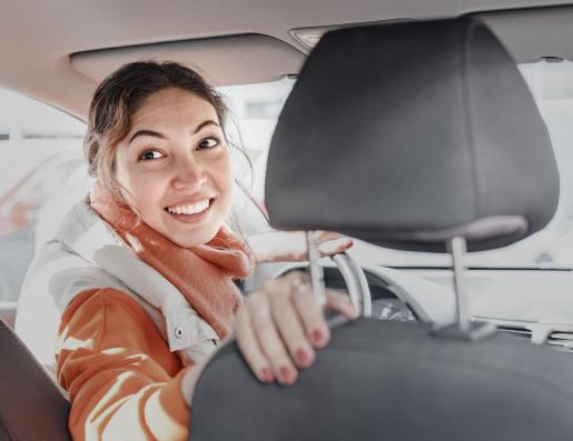 image d'une femme chauffeur de taxi qui se retourne au volant