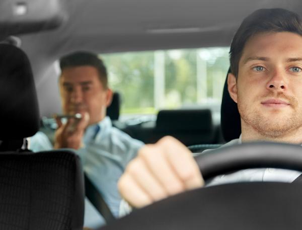 image d'un chauffeur de taxi avec un client sur les places arrières de la voiture