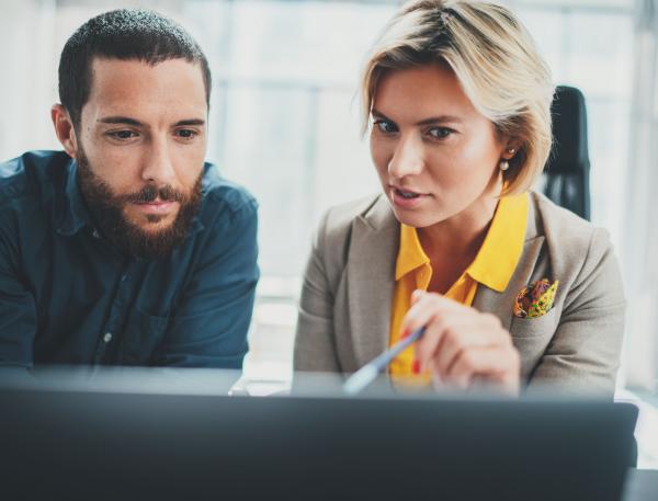 femme qui montre quelque chose sur son écran à un homme