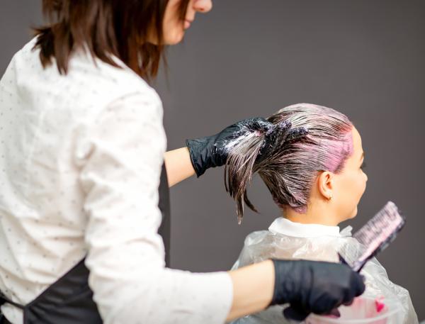 Coiffeuse en train d'appliquer une couleur à une cliente 