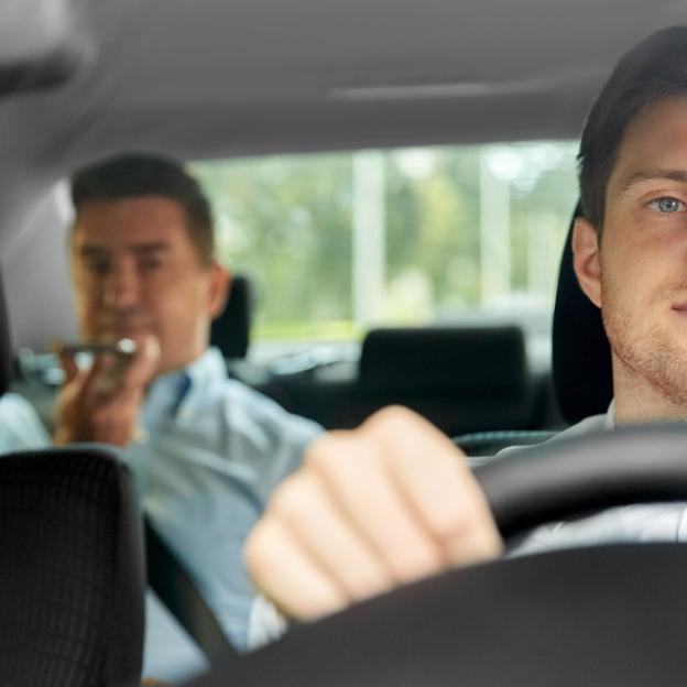 image d'un chauffeur de taxi avec un client sur les places arrières de la voiture